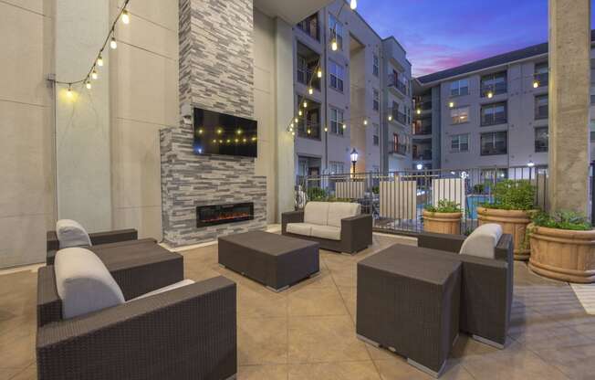 a patio with furniture and a fireplace in an apartment building