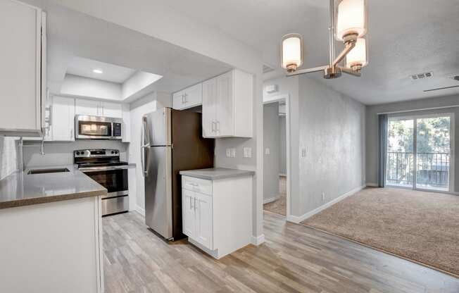 a renovated kitchen with white cabinets and stainless steel appliances