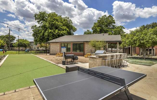 a tennis court and ping pong table in the backyard of a home  at Sunset Ridge, San Antonio