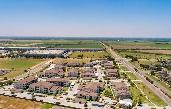 a large green field with trees in the background