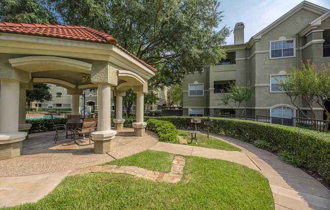 A building with a red roof and a patio with chairs and a table.