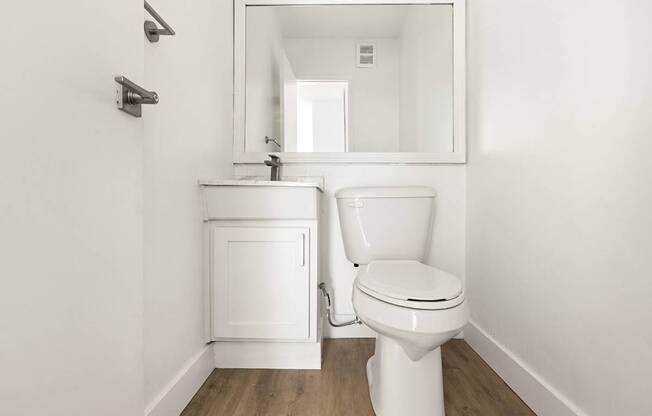 A white toilet and sink in a small bathroom.