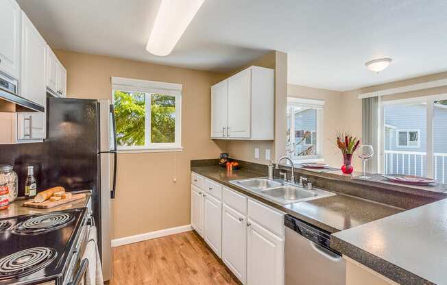 a kitchen with white cabinets and a sink and a refrigerator at Springfield, Renton Washington