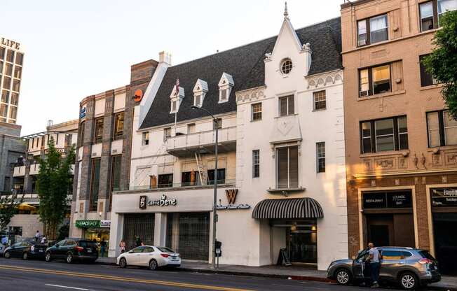 a white building with a black roof on a city street