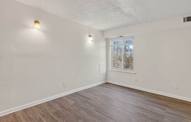A room with light wood flooring and white walls.