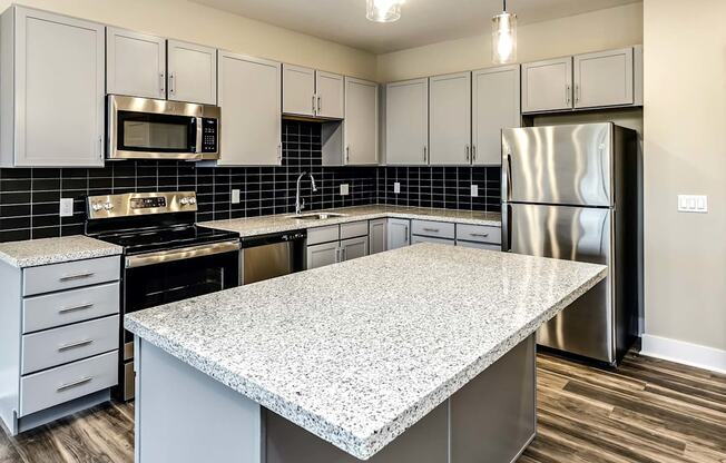 Large kitchens with white or black backsplashes at The Mill Apartments in Benson, NE