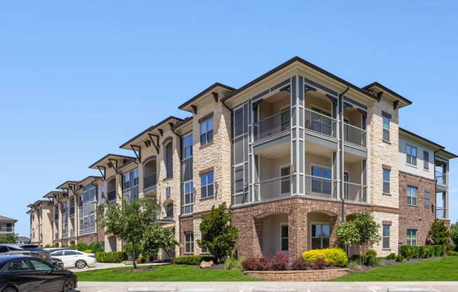 A large apartment building with a parking lot in front.