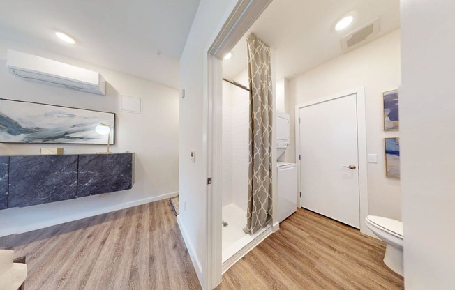 A bathroom with a marble countertop and wooden flooring.