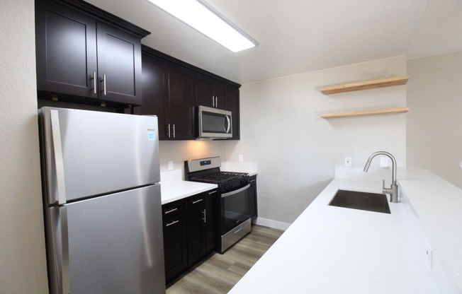 a kitchen with stainless steel appliances and black and white counter tops