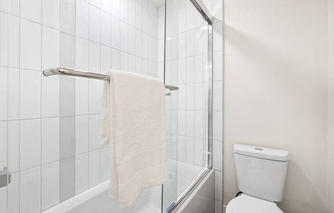 a white bathroom with a shower and a toilet