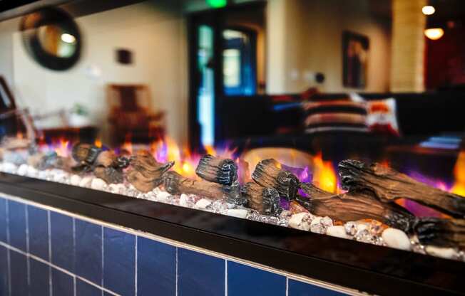 a fireplace in a restaurant with flames and rocks in front of it at Scouter's Mountain, Happy Valley, OR 97086