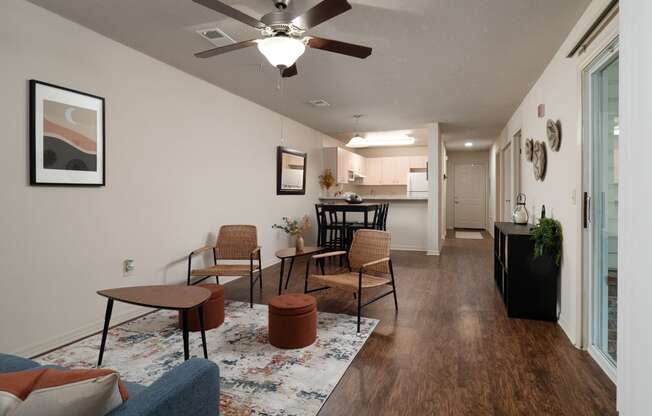 the view of a living room with a ceiling fan and a kitchen