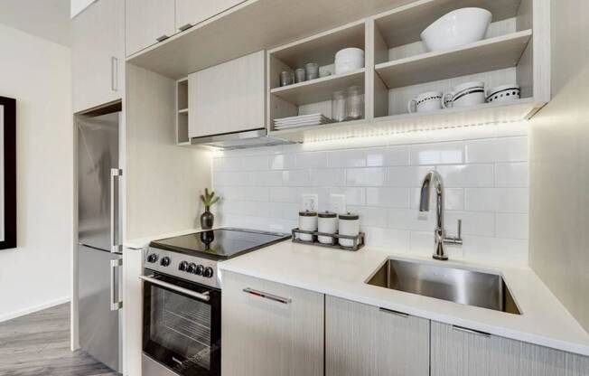 a white kitchen with a sink and a refrigerator