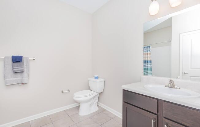 a white sink sitting under a mirror