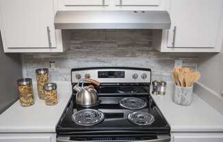 a small kitchen with a stove and a kettle on it