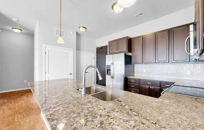 A kitchen with granite countertops and stainless steel appliances.