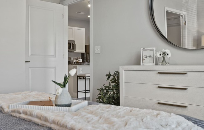 Decorated bedroom with dresser and a mirror at The Edison at Chapel Hills, Colorado Springs, 80920