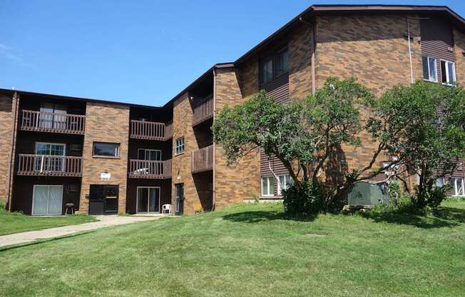 A large brick building with a green lawn in front.