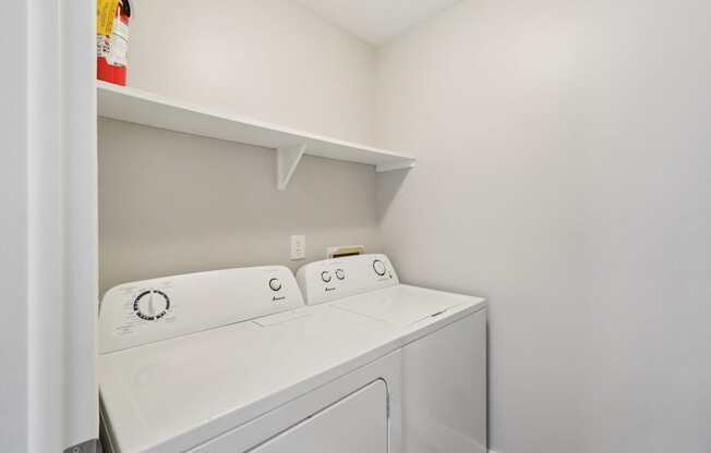A white washing machine in a small laundry room.