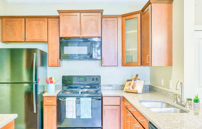 open concept kitchen with granite countertops, stainless steel appliances and oak cabinetry