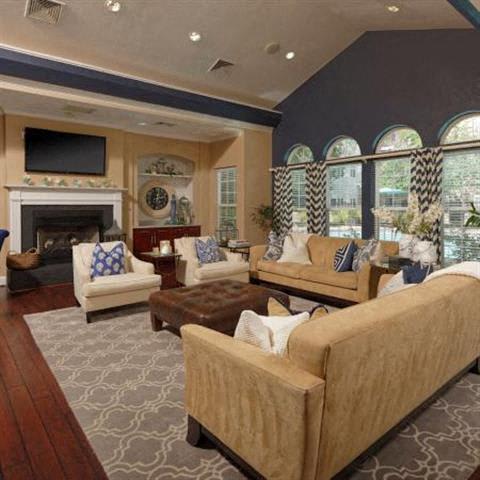 luxurious clubhouse with indoor seating area, television, and fireplace