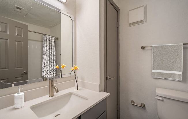 a white bathroom with a sink and a mirror