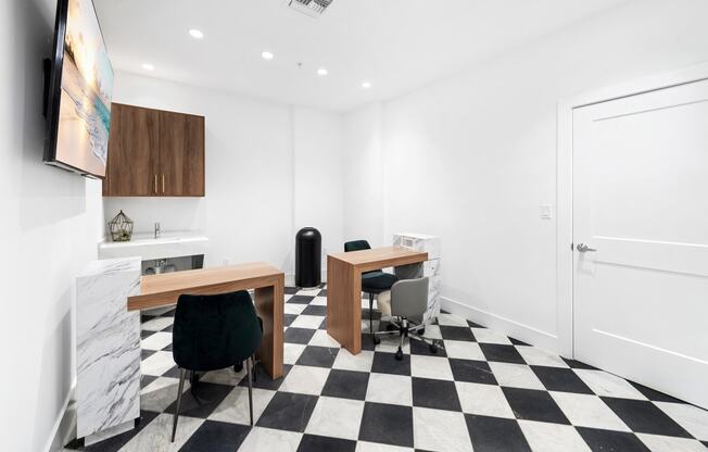 a room with a checkerboard floor and two desks