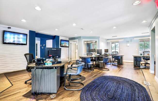 a conference room with desks and chairs and a tv