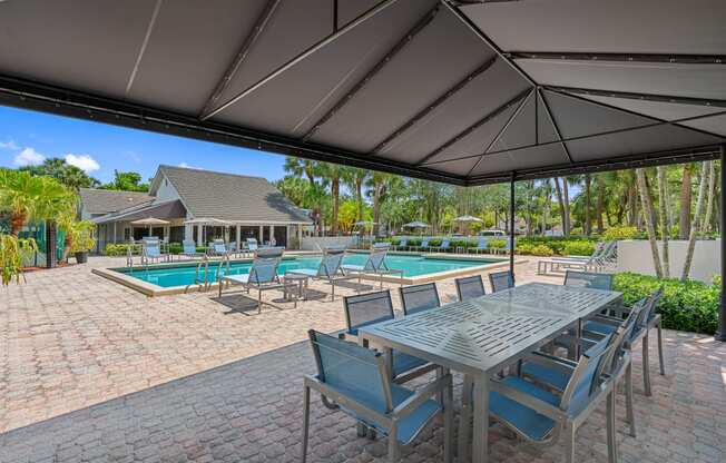 a patio with a table and chairs and a swimming pool