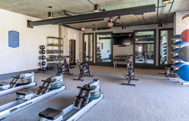 a gym with treadmills and other exercise equipment in a building with glass doors