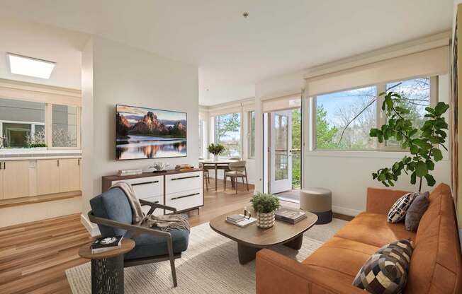 A living room with a brown couch and a TV mounted on the wall.