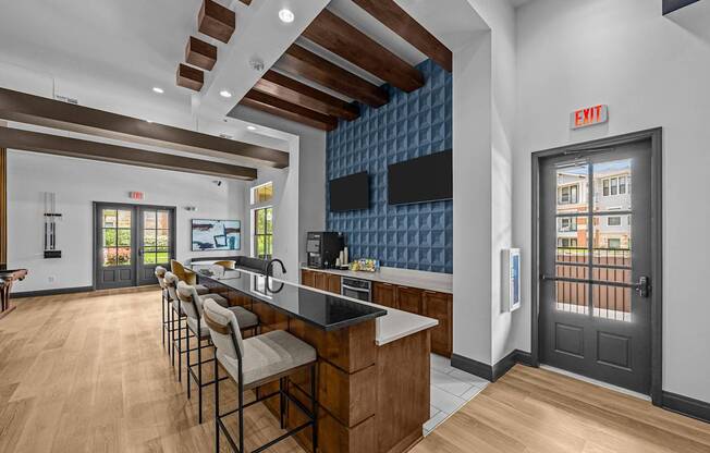 A kitchen with a bar area and chairs.