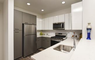 a kitchen with stainless steel appliances and white counter tops