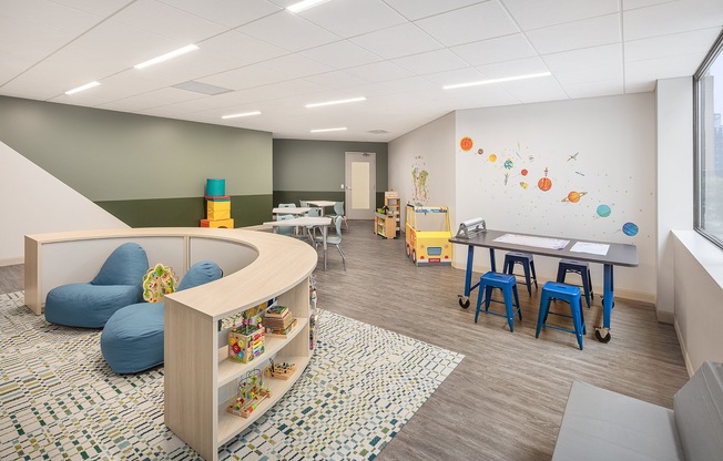 a childrens room with a play area and a table and chairs