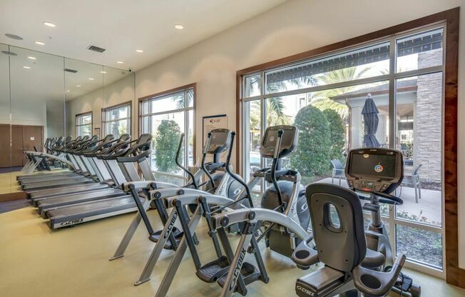 View of Fitness Center, Showing Treadmills, Ellipticals, and Stationary Bicycle at The Marq Highland Park Apartments
