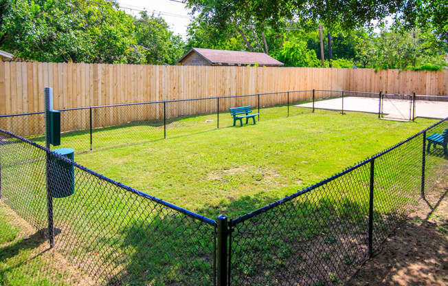 a fenced in backyard with a pool and a bench