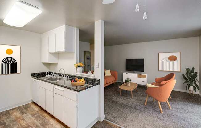 A kitchen with a black granite countertop and white cabinets.