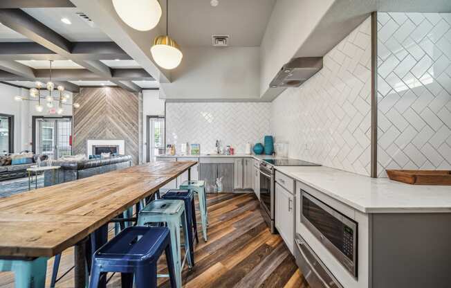 a kitchen with a long wooden table and blue stools