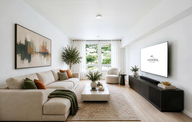 Bright living room with clean-lined furnishings, large windows, and an open layout that brings in natural light and connects to the surrounding neighborhood.