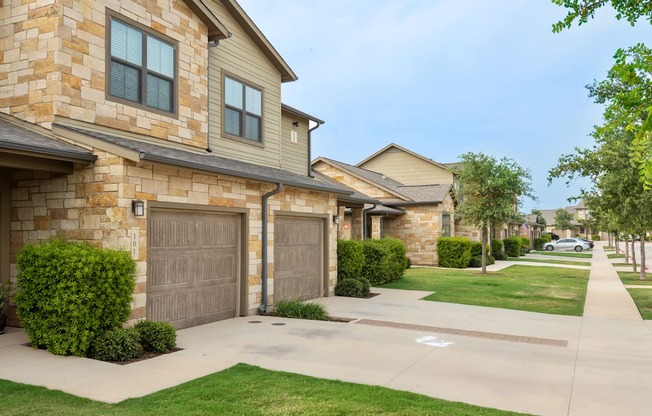 a house with two garages and a sidewalk in front of it