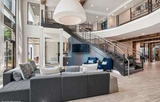 a living room with a large couch and a staircase