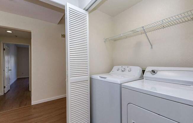 A white washing machine and dryer in a small laundry room.