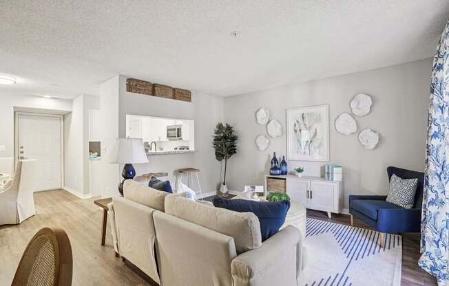 A living room with a white couch and a blue chair.