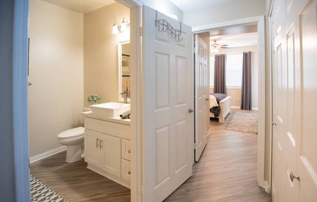 A bathroom with a toilet, sink, and mirror is shown.