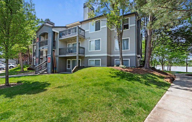 A large apartment building with a grassy front yard.