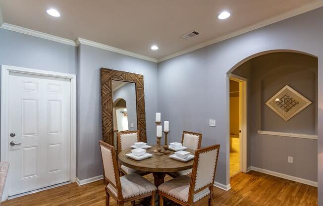 a dining room with a table and chairs and a mirror