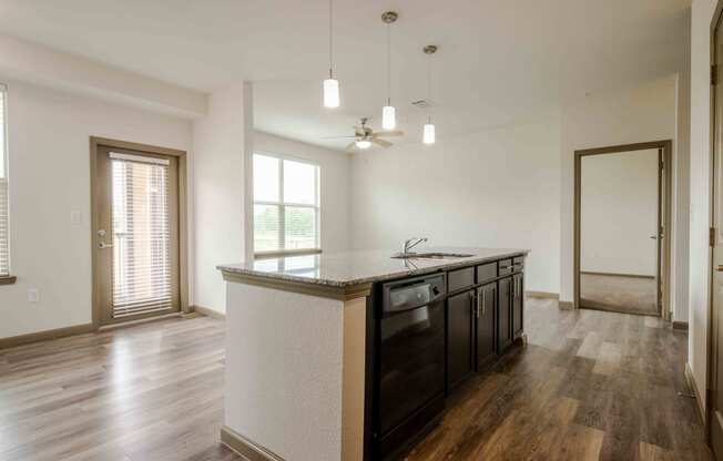 Open kitchen with wood flooring and island and sink and windows with blinds and ceiling fan