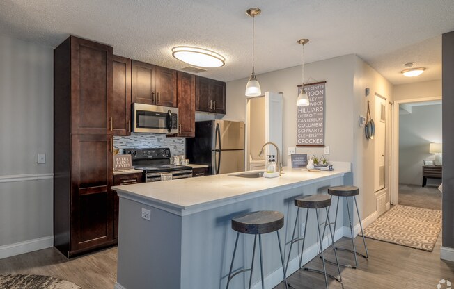 an open kitchen with a bar with three stools