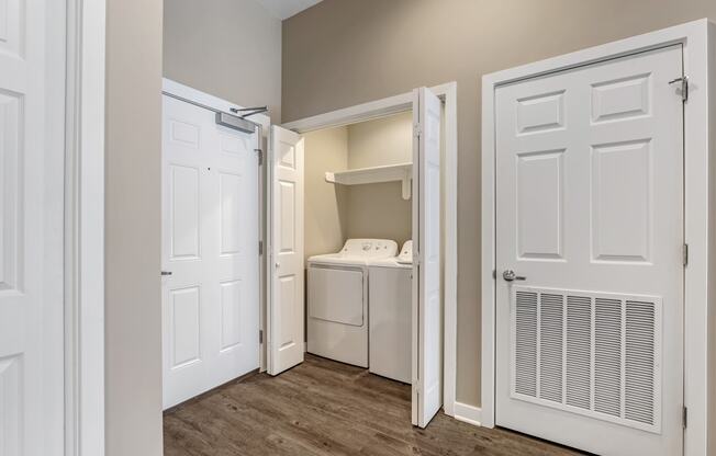 a laundry room with a washer and dryer and a closet with a door