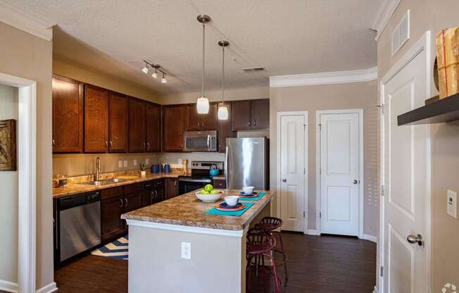 a kitchen with an island and a stainless steel refrigerator